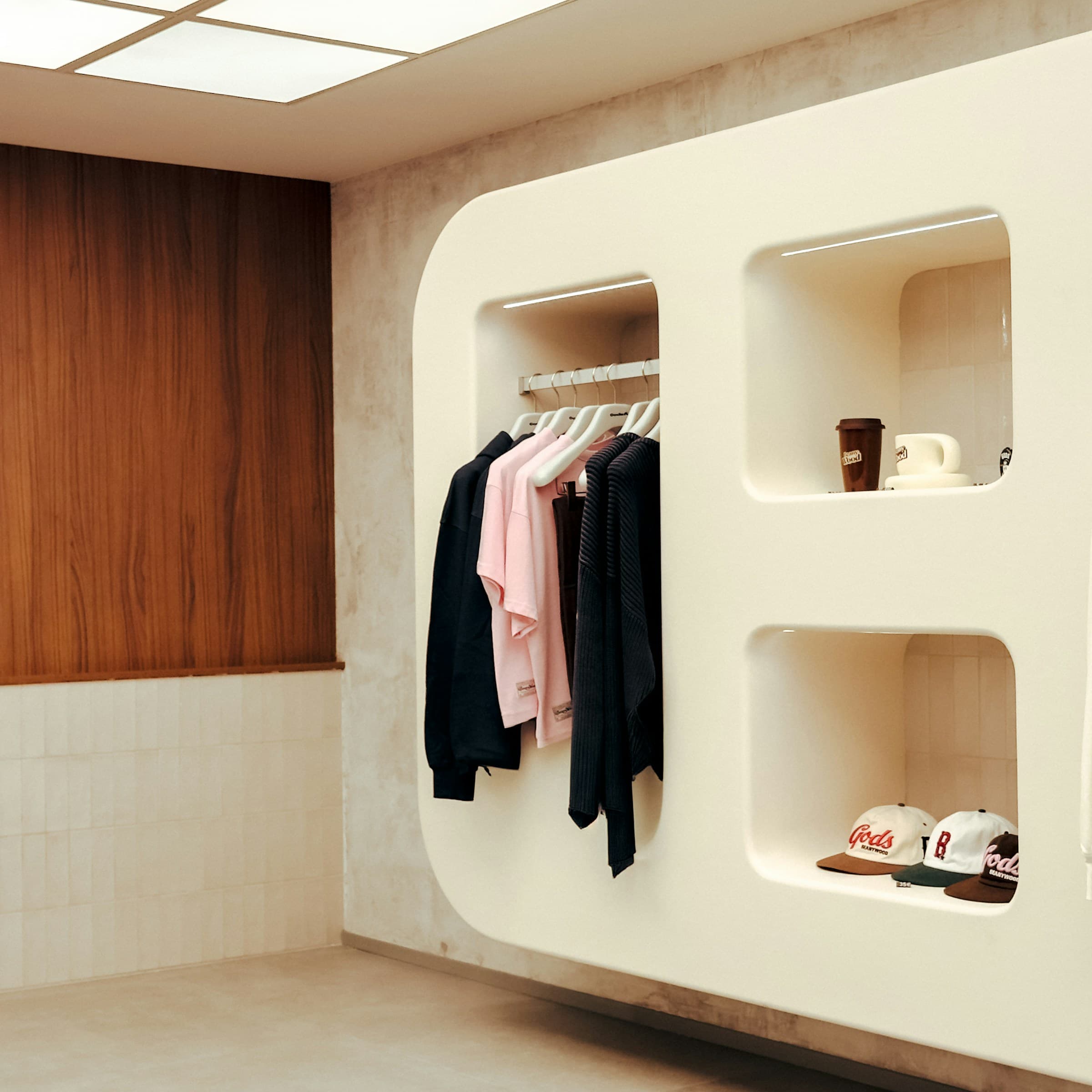 Rounded cream display niches and warm timber wall panels in a boutique.