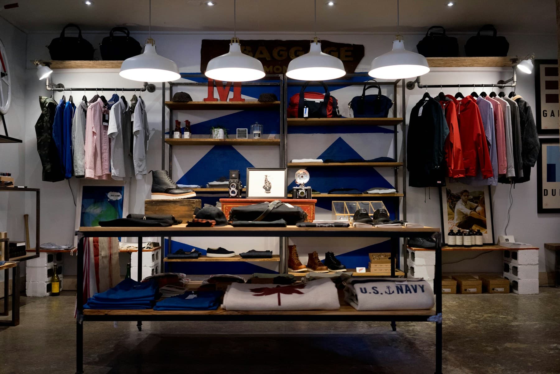 Timber and black steel retail displays beneath white pendant lights.