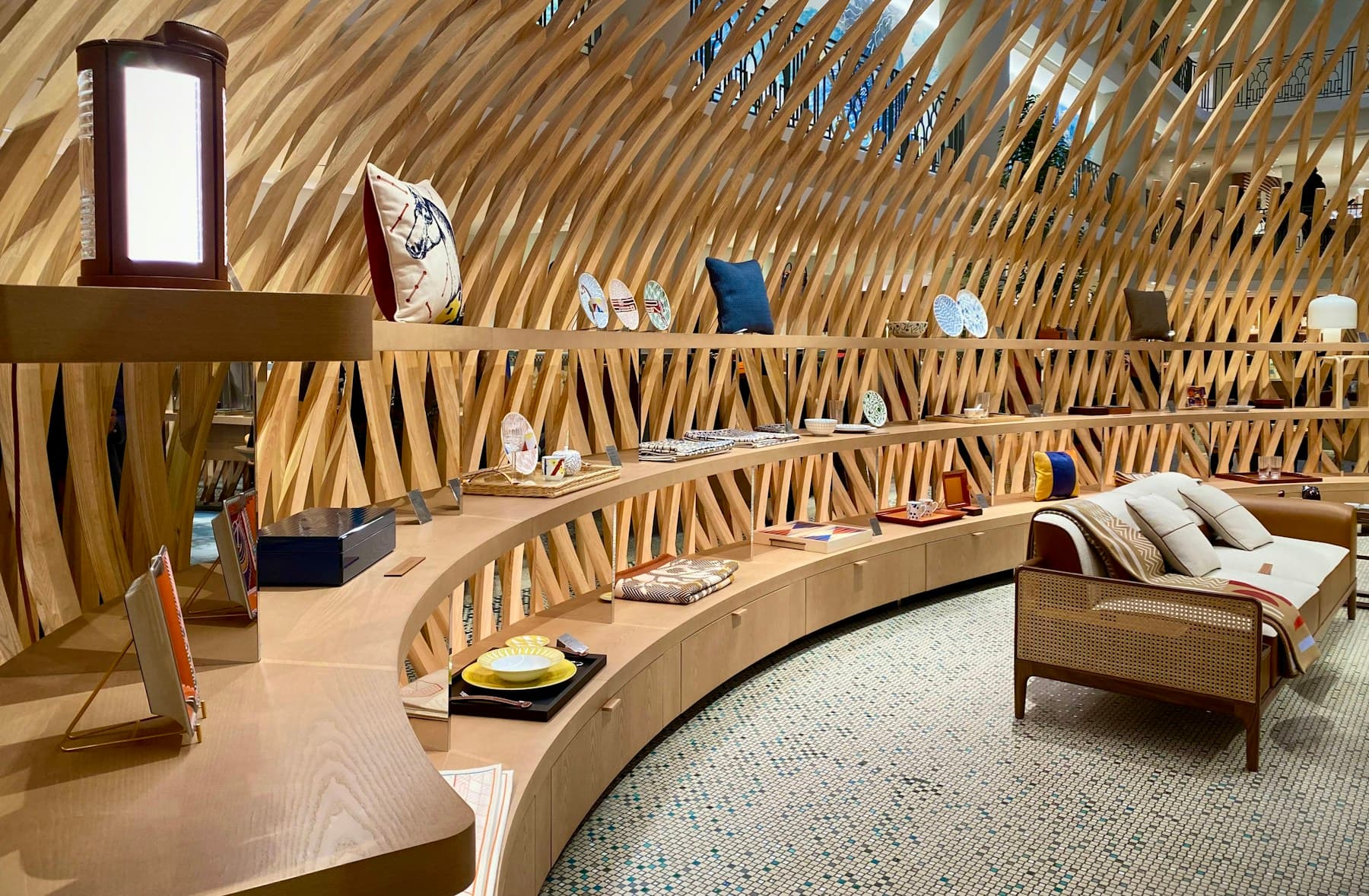 Curved timber lattice retail interior displaying homeware and textiles.